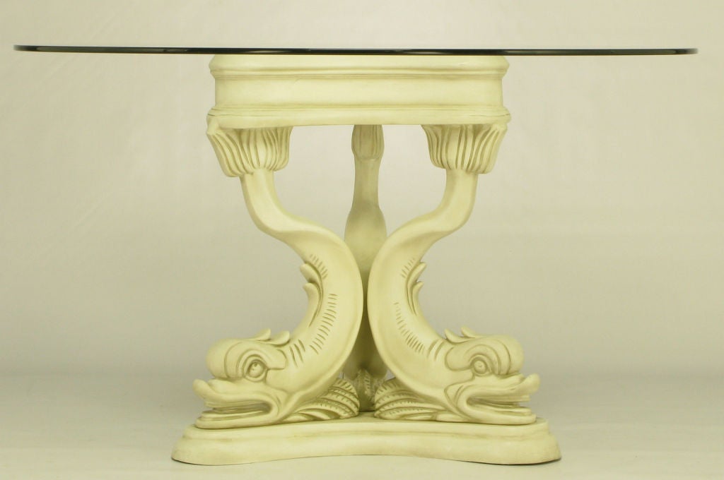 Impressive trio of dolphins made of heavy cast gesso and resin, with an antiqued ivory lacquer finish. French inspired piece would work well as a center table as well as an intimate dining table.  Round glass top is 1/2