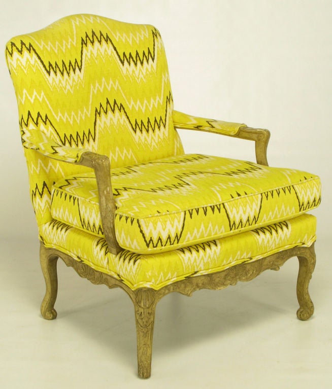 Pair of Louis XV fauteuils with matching ottoman in a auerolin yellow, black and white geometric linen upholstery. Carved wood frames have been lacquered and antiqued to resemble an aged light fruitwood.