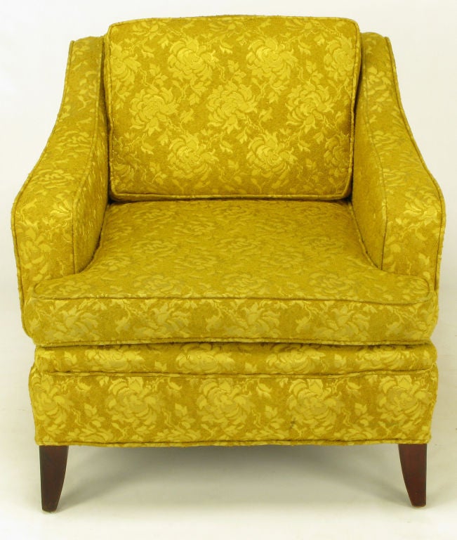 Curvaceous lines, button tufted arms, and carved mahogany saber legs give this classic lounge chair a strong profile. The tactile gold damask upholstery is older but in very good condition.