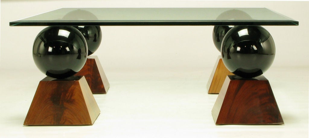 Four black gloss lacquered resin balls surmount burled mahogany truncated pyramids, supporting a square 5/8