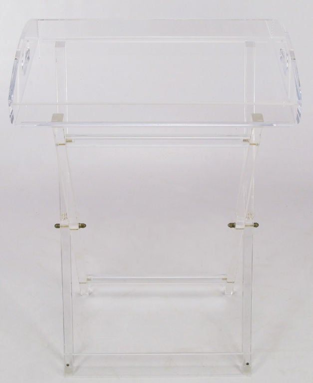 Folding X-based Lucite tray table, with stops of horizontal cylinders. Removable tray is made of shaped Lucite, with kidney shaped opening handles. Stand and tray both recently polished.