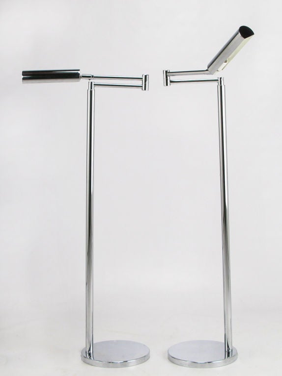 Pair articulated chrome floor / reading lamps. Tubular three-quarter round shades are articulated and the arms swivel. Incandescent illumination up to 100 watts.
