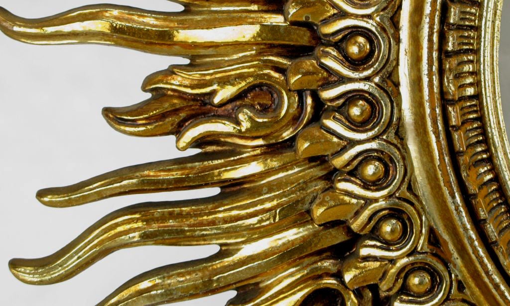 Large and beautifully designed patinated gold leaf over resin sunburst mirror. Nearly 4 feet in diameter, this would make an incredible over-mantel piece.