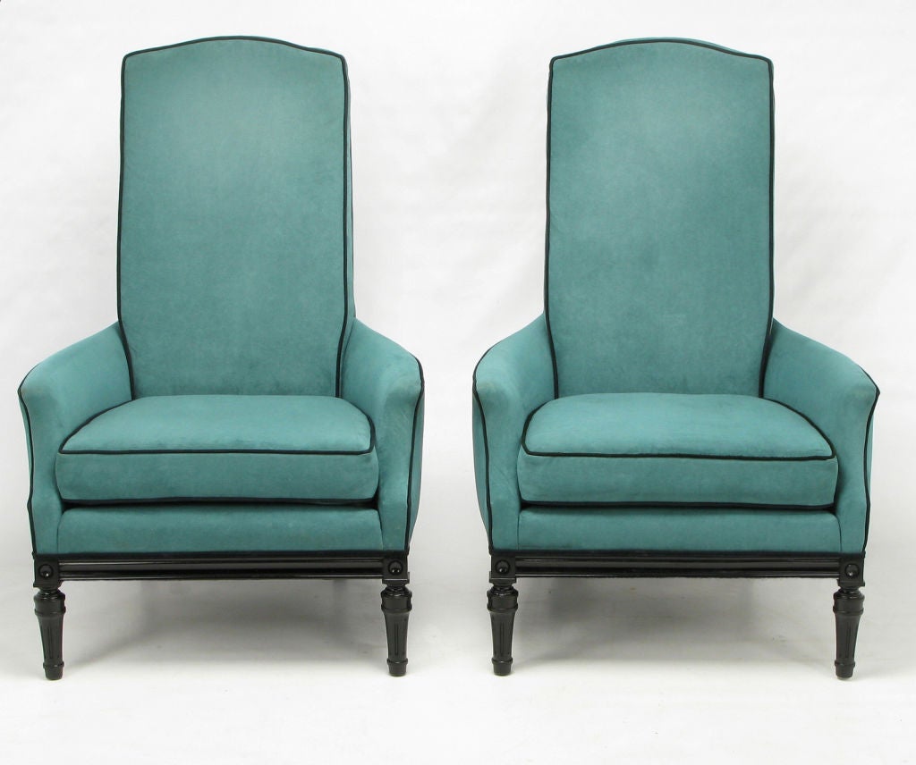 Striking pair of custom high back lounge chairs in turquoise ultrasuede, with contrasting black ultra suede welting. Back cushion fitted with loose seat cushion. Carved and black lacquered modern regency styling to the skirt and legs.