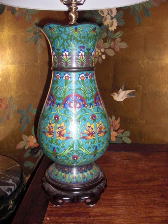 A beautiful pair of probably Chinese [ they are possibly Japanese ] cloisonne vases mounted into lamps on carved hardwood bases.They were probably mounted as lamps in the 70's and similar cloisonee finials from that period. The blue/green color is