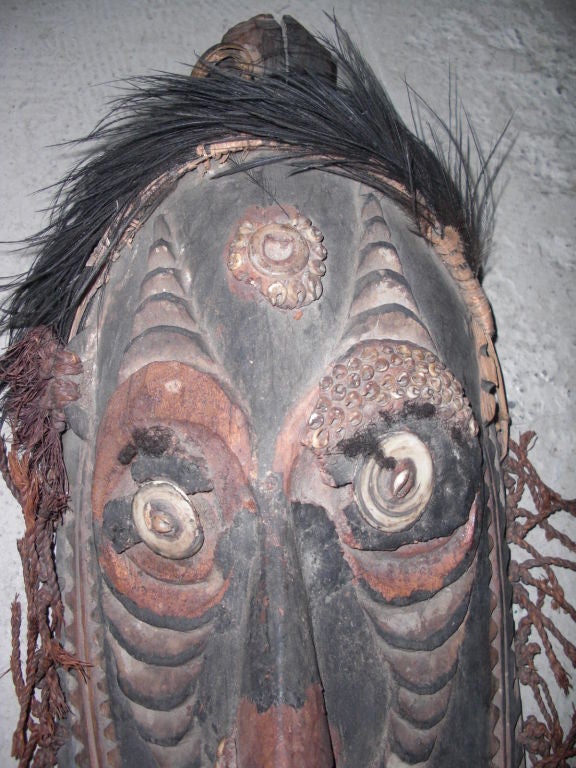 A carved , painted and adorned New Guinea ceremonial mask . Please see our other posting for some information regarding the four masks we posted today. Probably from the lower Sepik region of New Guinea. This one has some significant losses but it's
