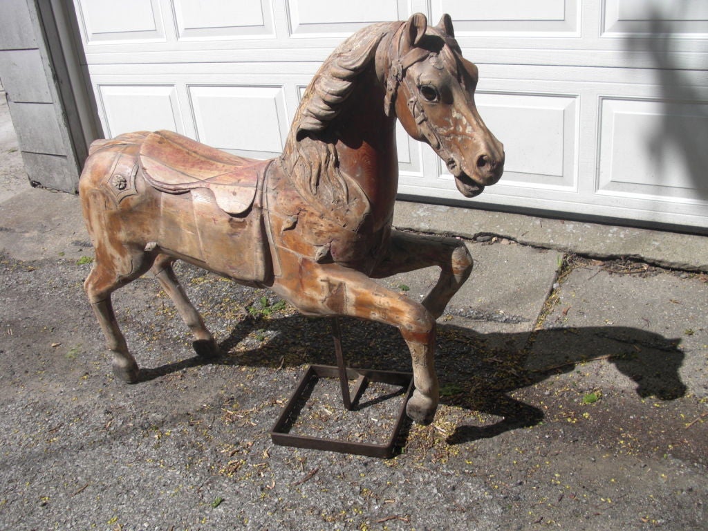 A very nicely carved late 19th/early 20th century American carved wood carousell horse on custom stand. This carousel horse is particularly well carved and has original, beautifully expressive glass eyes. It was stripped of its original paint and a