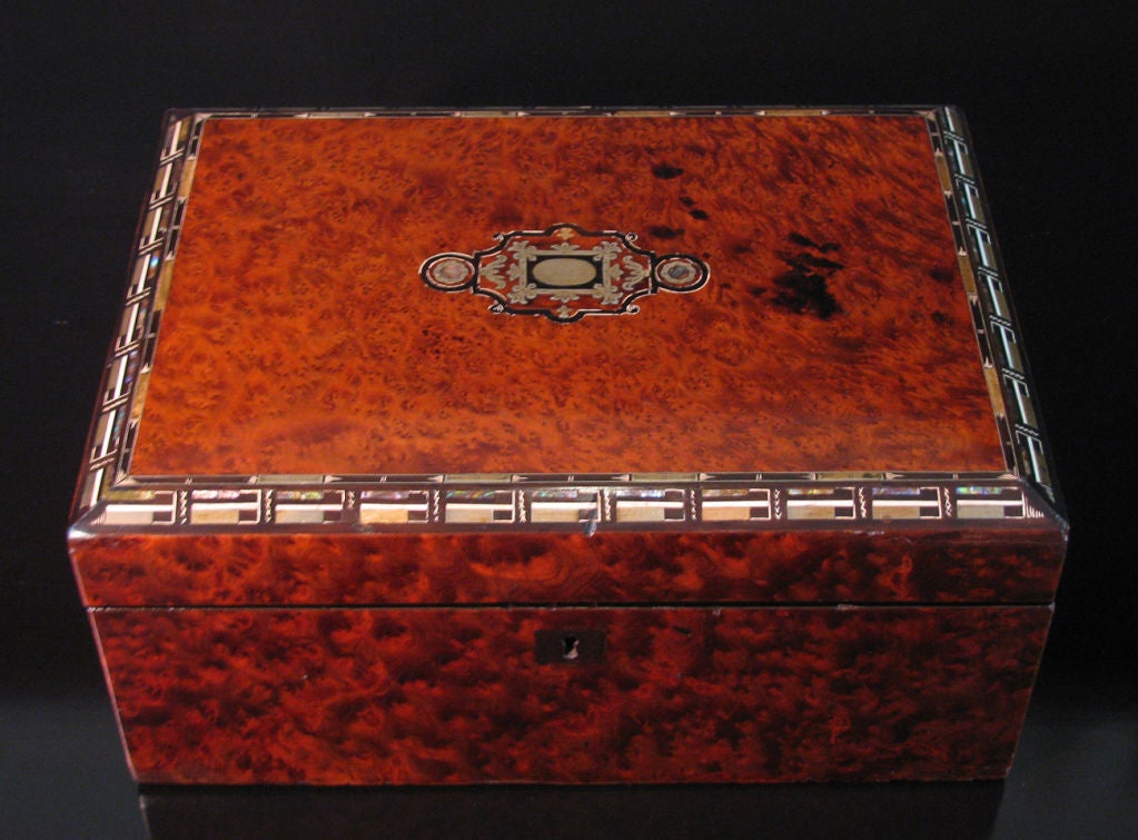 A beautiful polished walnut lap desk with mother pearl, abalone, and horn inlay border along top of box. Open the top and the box becomes a lap desk with embossed leather, and below are hidden compartments for storage, and two crystal ink wells with