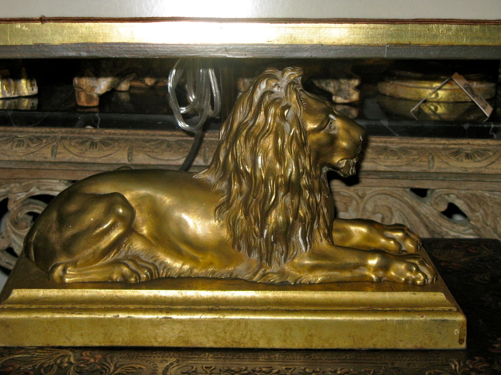 Stunning bronze lion mounted on a gilt wood base.  The lion has been french wired and crowned with a hand painted parchment shade.