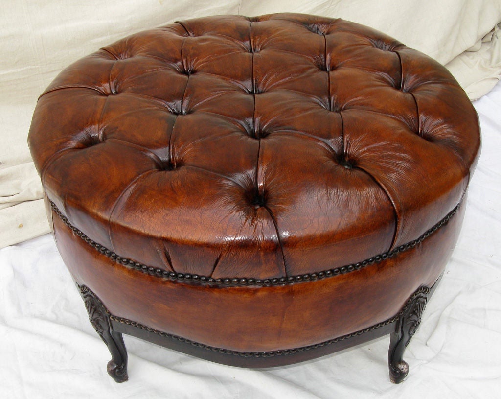 Pair of French Leather tufted benches/ottomans with nailhead trim detail.  The carved frames have an ebony finish.