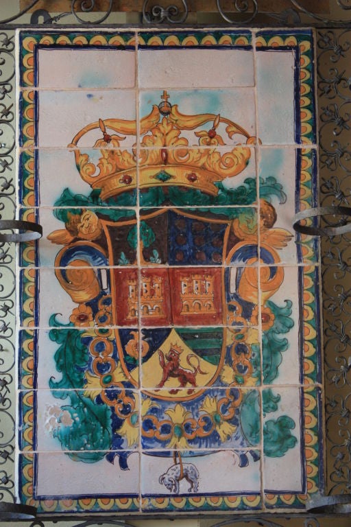 Hand painted tile mural mounted in hand wrought iron from Portugal. The Moroccan influence can be seen in the incredibly detailed iron border which is age-appropriately banded and bolted.  The pot holders on the sides are 5-3/4