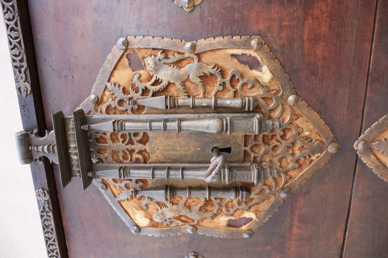 This has the right out Of a Mizner look with masterwork elaborate hand wrought iron though out and early wormy walnut all set off by it''s over scale size.You would wrestle to throw this one back as it weighs around 300 pounds.