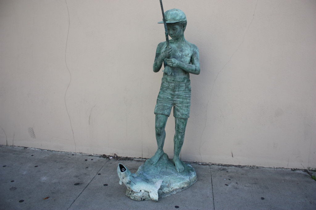 Great looking bronze statue of a child catching a whopper fish.The base is signed 