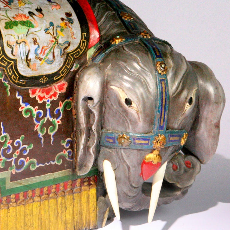 Whimsical and decorative carved wood garden seat or footstool in the shape of an Indian elephant.   Wonderfully detailed and brightly painted with colorful saddle and head halter.  The elephant, epitome of strength, also symbolizes prosperity,