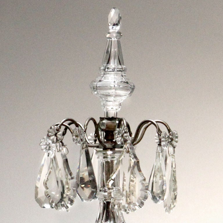 Shimmering pair of five-branch crystal table candelabras with large cut-crystal drops. Each topped by large crystal finial.
