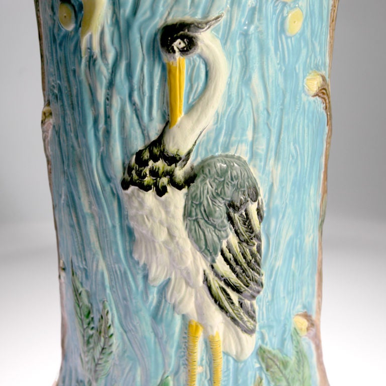 Majolica umbrella or stick stand on a light blue ground with a heron figure on one side and an ostrich figure on the other side.