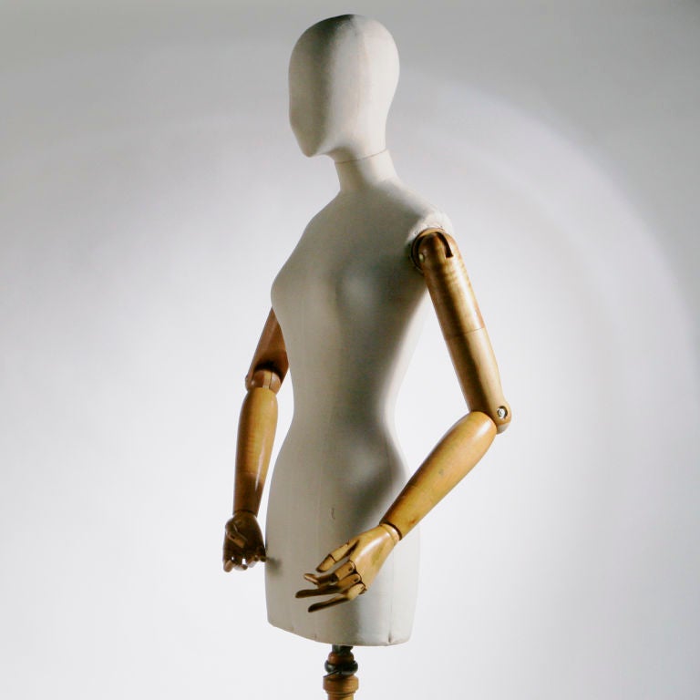 Life-size French mannequin or dress form in wood and canvas complete with articulated arms and fingers.  Hand-made in Paris by Stockman (in business since 1867) in the early 1920's.  On the original wood tripod stand.