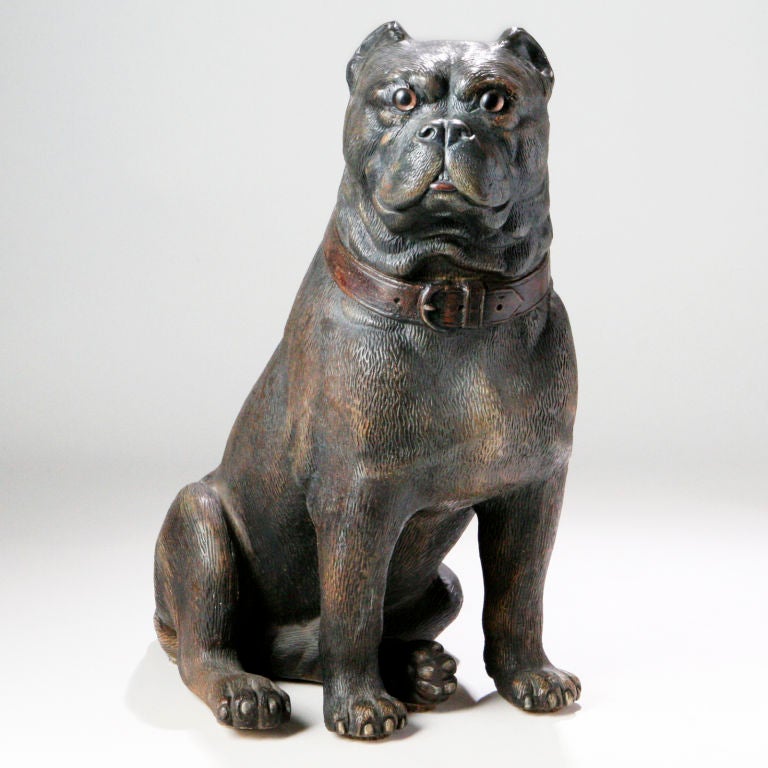 Bulldog inglés victoriano de terracota de gran tamaño con las orejas recortadas en posición sentada. En el típico esmalte cerámico marrón y con ojos de cristal y nariz negra frotada.