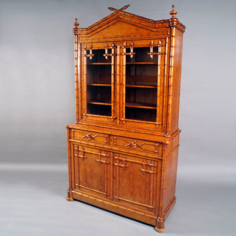 Beautifully crafted English bamboo and birdseye maple breakfront cabinet in two pieces.  Three adjustable shelves behind glass doors of top cabinet and one adjustable shelf behind doors of lower cabinet.   Two narrow drawers in lower piece have