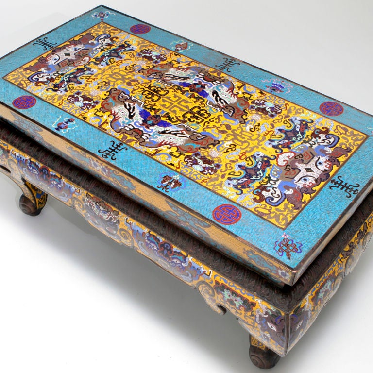 Colorful vintage Chinese cloisonné coffee table with decorative apron and cabriole legs. Upper portion of each leg decorated with stylized dragon face. The table enameling in yellow with bright turquoise and red accents, circa 1920s.