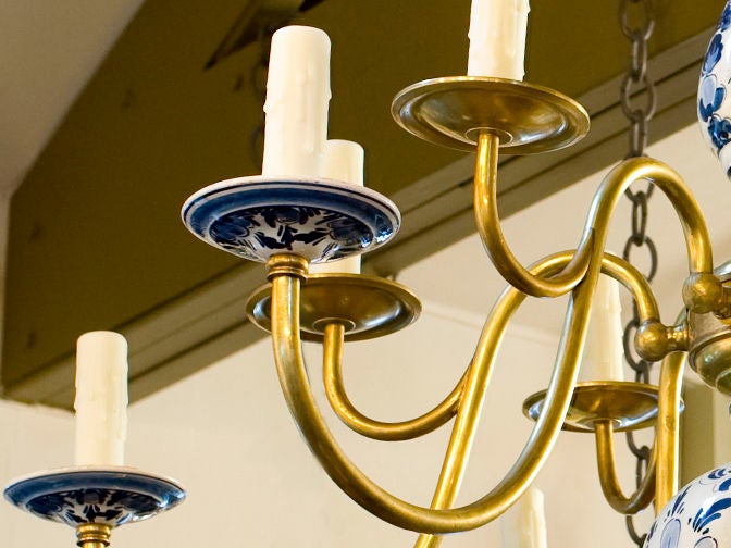 Beautiful blue and white chandelier with brass arms and loop.  Total of twelve lights with two per arm.
