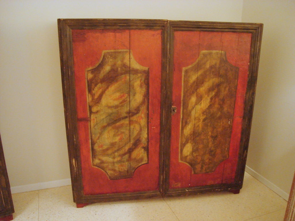 Handsome pair of painted cabinets from the Catalan region of Spain. Triple reeded moldings on edge of doors and repeated on sides of case. Painted rectangles on the door fronts depicting architectural moldings in faux marble. Reddish background with