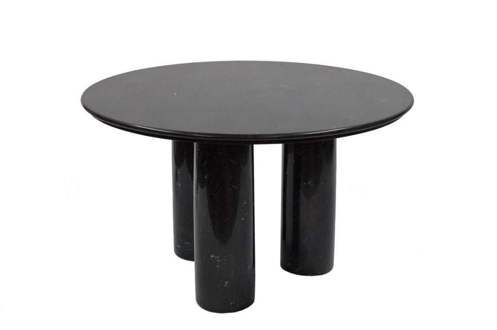 Dining table made of solid black marble, round top and three columnar legs. Made by Cassina.