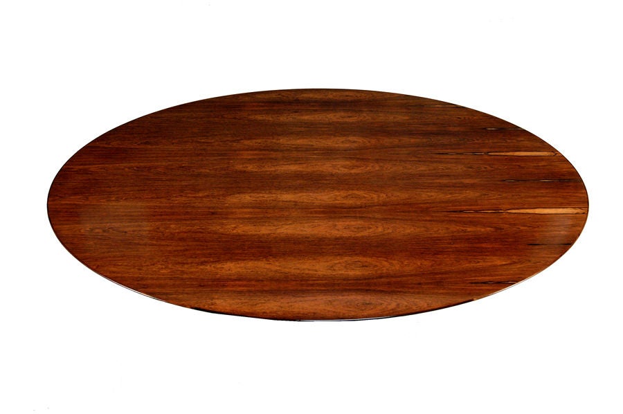 Beautifully grained Brazilian rosewood oval top on oval white painted metal base. Made by Knoll.