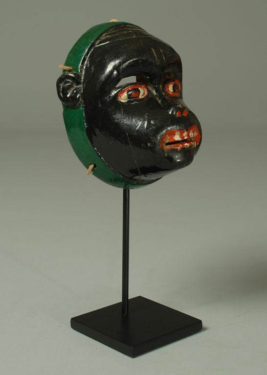 A superb vintage Guatemalan monkey mask from Rabinal. Carved and polychrome painted wood with painted eyes and green trim.

Dimensions: approximately 6 inches x 5 inches. Overall height, including display stand, is 11 inches.