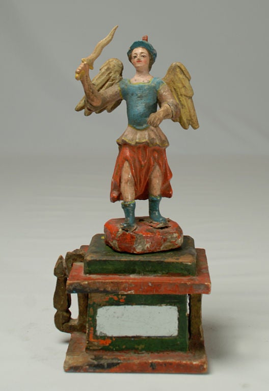 This early 19th century carved and polychrome painted santo represents San Miguel Archangel, patron saint of warriors and soldiers. Saint Michael, leader of the forces of heaven in the triumph over the forces of evil, is usually depicted as he is