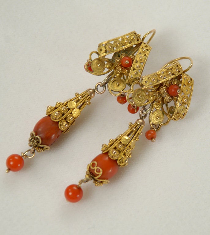 A pair of wonderful antique Mexican earrings in 12 - 14 karat gold with skillfully crafted gold wire, filigree and beautiful coral beads. Oaxaca - first quarter 20th century.
Dimensions: hang 2.75 inches.

Condition is excellent.