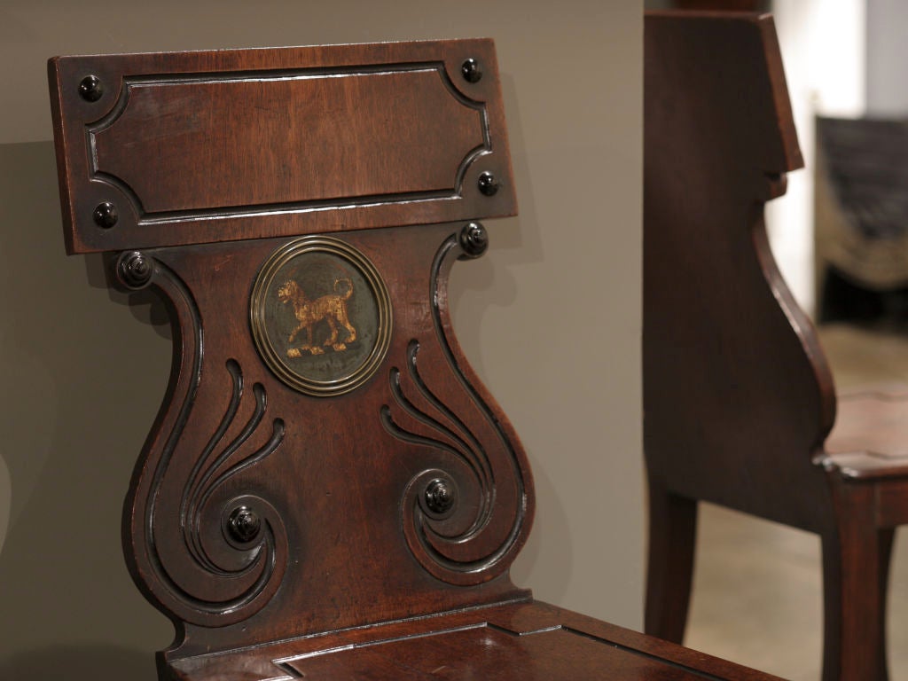 A pair of Regency mahogany and brass mounted Hall Chairs