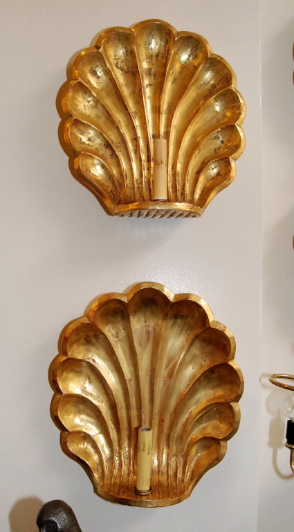 Pair of hand-carved wood shell design wall sconces with 22-karat gold finish.