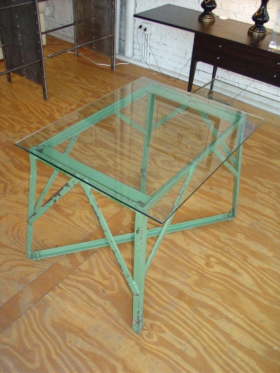 A steel Industrial table with a glass top.