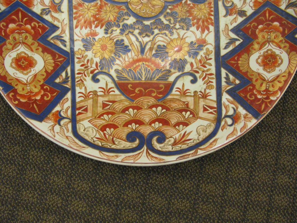 An unusually large antique Japanese imari charger.

With boldly painted geometric and floral design, and central motif of flowers in a basket.

Gold, blue and orange on white background.