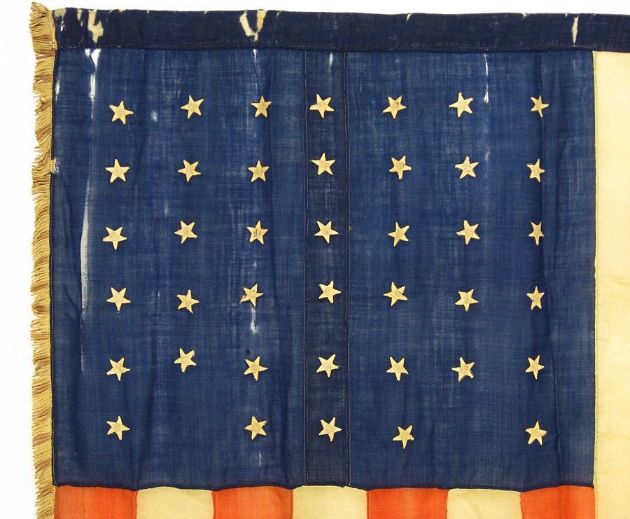 RARE INDIAN WARS PERIOD, UNION INFANTRY BATTLE FLAG IN AN EQUALLY RARE, UNOFFICIAL STAR COUNT. 40 STARS, 1889, WITH A NOTCHED STAR CONFIGURATION AND UNUSUAL, CANDY-STRIPE FRINGE, PROBABLY MADE ON THE GREAT PLAINS:<br />
<br />
Rare U.S. Infantry,