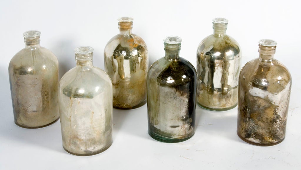 Mercury glass bottles with stoppers. Each one is unique in relation to color and would make wonderful ornaments or vessels. Price is per bottle.