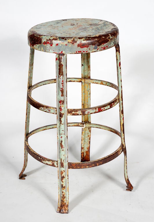 Small industrial work stool. Was previously painted green and red but the paint has worn off to create a distressed finish.
