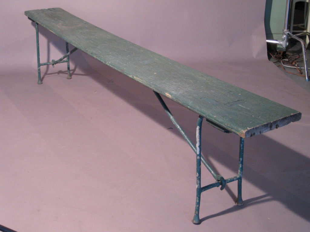 Long wooden bench with folding iron legs used in gymnasiums c.1920's. All original green paint. Beautiful patina.<br />
<br />
WEEKLY DELIVERIES TO MANHATTAN FOR APPROVAL OR SALES. DELIVERY FEE IS $100.