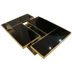 A Brass and Black Glass Cocktail Table with Hidden Interior Bar