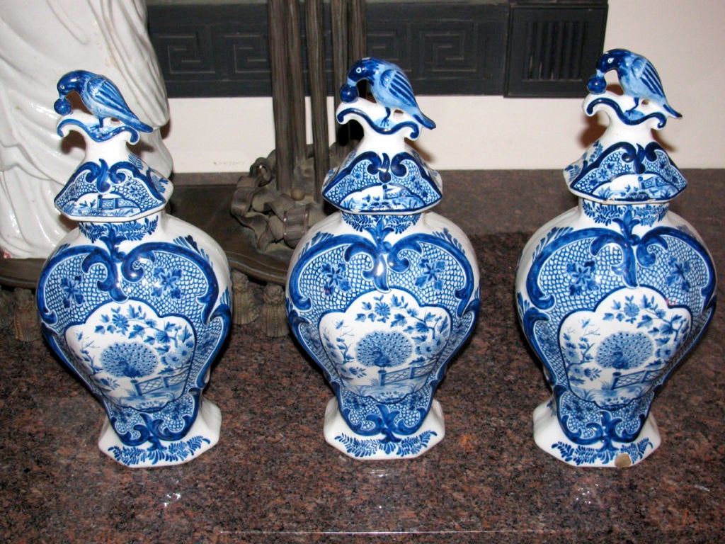 A Dutch Delft Blue and White Five Piece Garniture consisting of two vases and three urns with bird lids.<br />
Provenance:  A.C. Barnes, London<br />
Literature:  R.P. Wunder, 