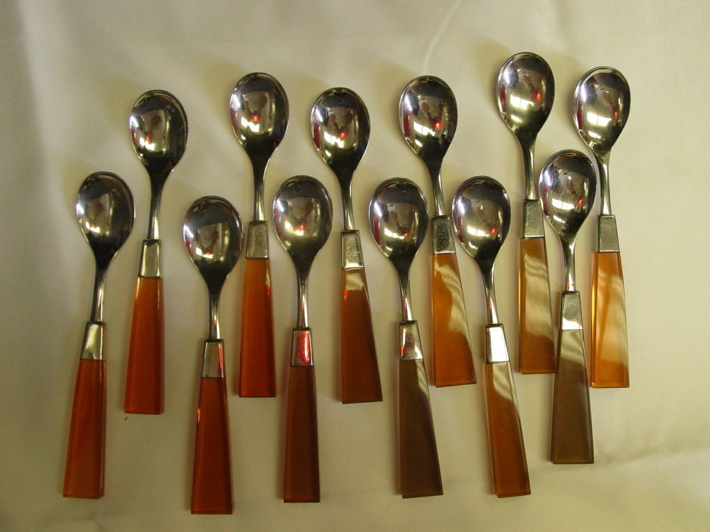 Incredible set of French Lucite flatware for twelve.  12 6 piece settings. with an incredible orange color we have never seen before.  There is variation in the color of the butter knives from orange to a deep bronze. Two salad servers included.