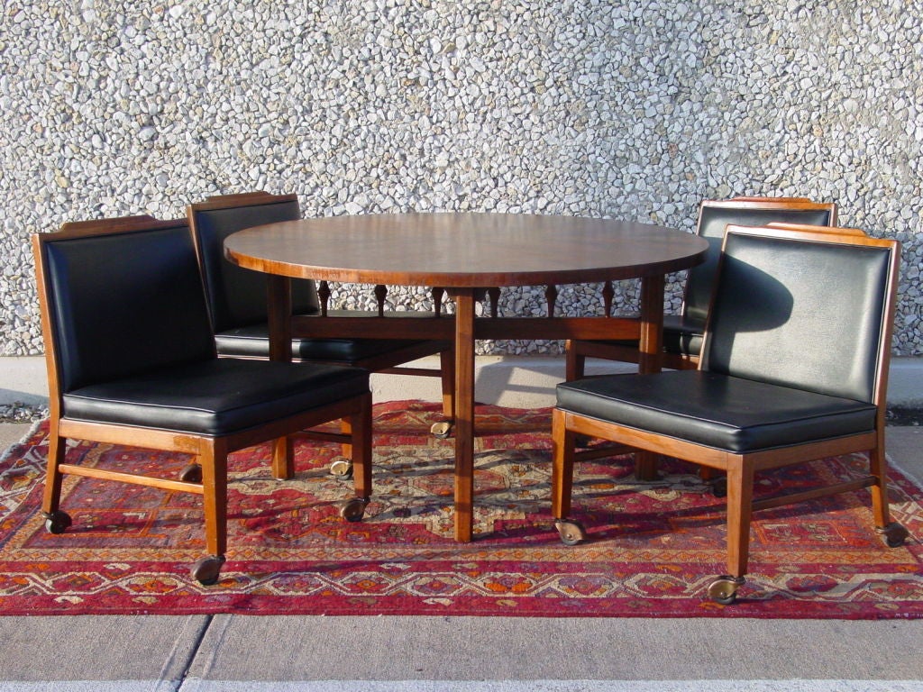 Excellent example of the form.  Five piece set consisting of a round game or bridge table and four low chairs.  Table top is veneered in book-matched walnut, divided into quarters by a 1 3/4 inch 