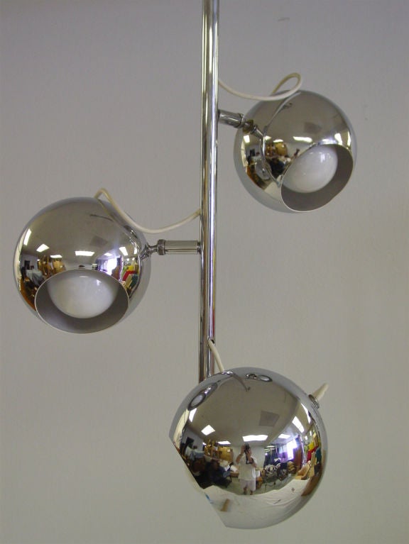 Three light adjustable eyeball fixture in gleaming chrome. Chrome spheres are attached to simple chrome rod, and pivot approximately 120 degrees in all directions and rotate 360 degrees. Lights can be directed in virtually any direction. Maximum
