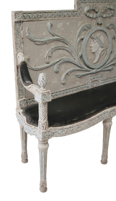 An Italian neo-classical carved and painted hall bench with original decoration.  The stepped back with swagged laurel wreath crest above a central roman portrait medallion and<br />
crossed boughs within a guilloche border, padded arms and