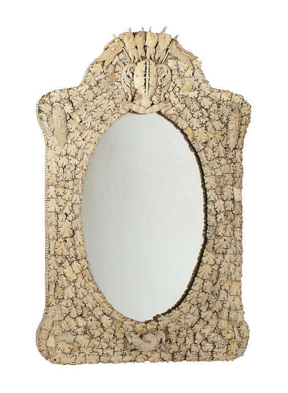 Pair of French Dieppe bone ivory mirrors with oval plates within rectangular arched -top surrounds composed of overlapping leaves <br />
and with flag crest ornament
