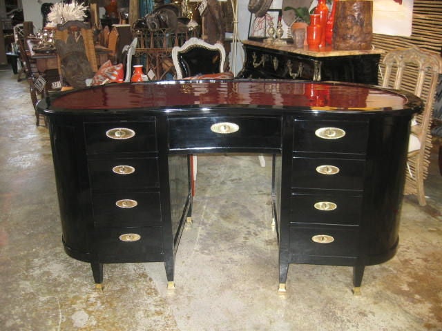 Newly lacquered kidney shaped desk. Burgundy area is inset and topped by a custom cut piece of glass. Glass top is not in photos. Brass hardware and sabots. Lockable drawers. The knee hole opening is 24