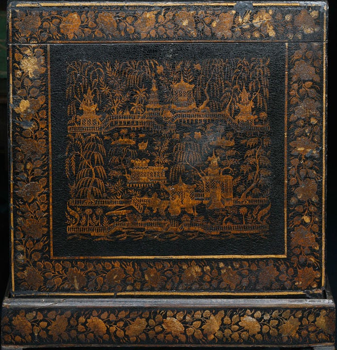 Chest on stand, painted and varnished with gold-colored designs

on a black ground,  in two parts decorated

overall with chinoiserie scenes. Made in Bareilly India.

Similar example in the V&A museum and illustrated in Furniture from