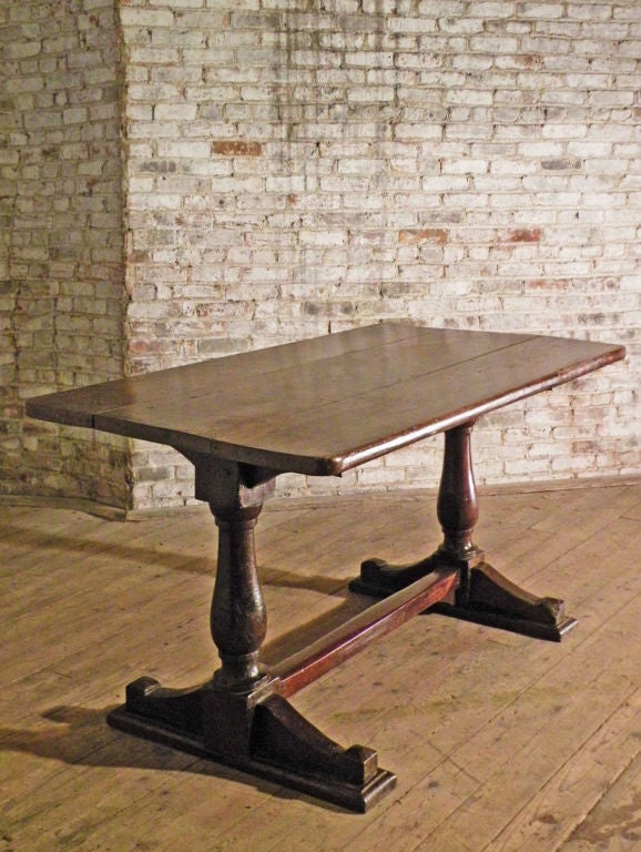 Beautiful, well proportioned trestle table with a rich patina.
The three-plank top supported by baluster-turned legs on each end, ending in shoe feet, connected by a square stretcher.