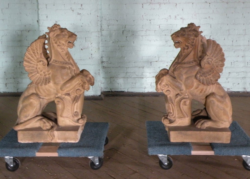 Well articulated, impressive pair of terra cotta winged Lions, in seated position and holding heraldic shields between their front paws.
The winged lion symbolizes the city Venice, Italy, as well as one of its patron saints, St Mark.
